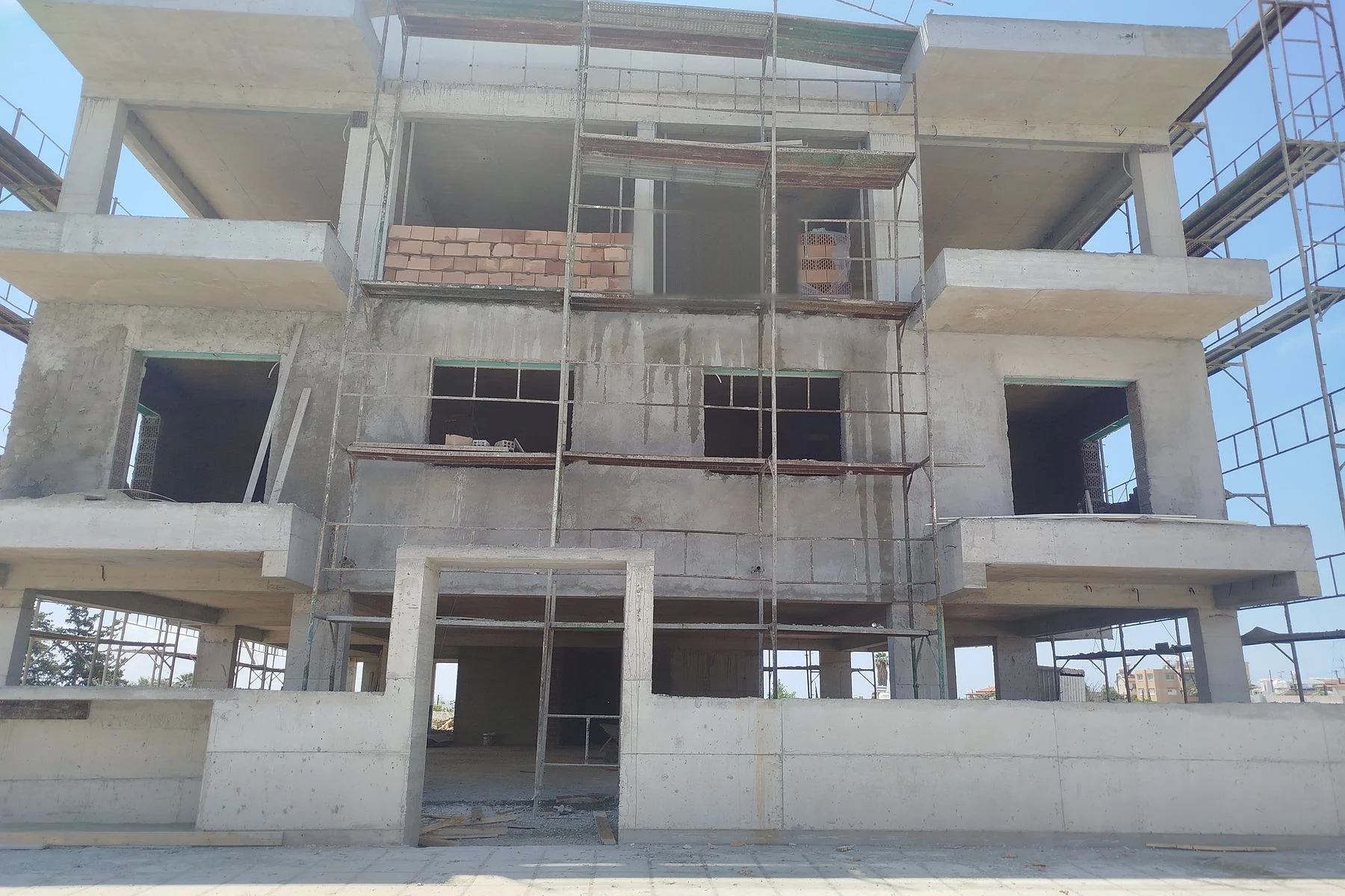 Ο σκελετός της πολυκατοικίας Euphoria Apartments με σκαλωσιές, 23/05/2026.