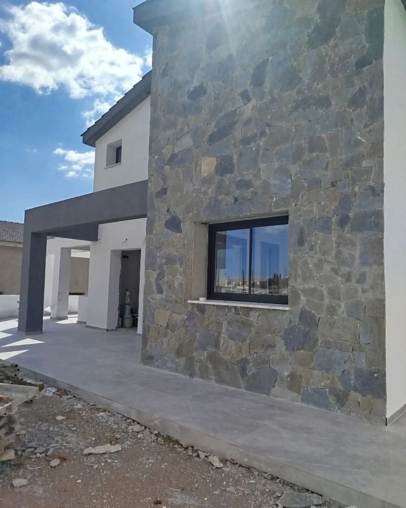 Η πέτρινη επένδυση ολοκληρωμένη, με το εργοτάξιο ακόμη ανοιχτό, Σούνι, 11/03/2026.